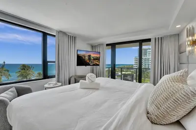 a bedroom with a large white bed and large windows at Beautiful Oceanfront 3BDR Condo 801 in Miami Beach