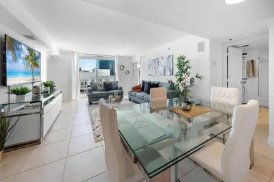 a dining room and living room with a glass table at Stylish 2BR With Skyline Views, Free Parking, Sleeps 8 in Miami