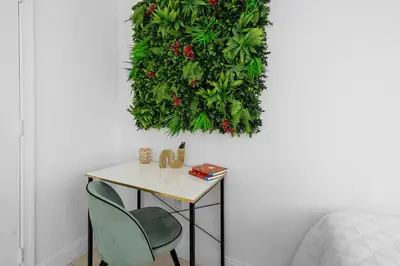 a table and two chairs and a plant hanging on a wall at Stylish 2BR With Skyline Views, Free Parking, Sleeps 8 in Miami