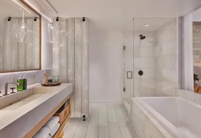 a bathroom with a tub and a sink and a shower at 1 Hotel South Beach in Miami Beach