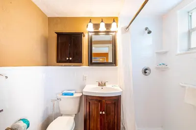 a bathroom with a toilet and a sink and a shower at Enchanted Isle Hollywood Beach Resort in Hollywood