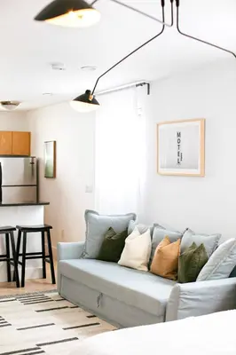 a living room with a blue couch with pillows at Spacious Apt in the heart of South Beach in Miami Beach