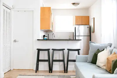 a living room with a couch and a kitchen at Spacious Apt in the heart of South Beach in Miami Beach