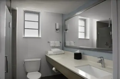 a bathroom with a sink and a toilet and a mirror at Hilton Garden Inn Miami South Beach in Miami Beach