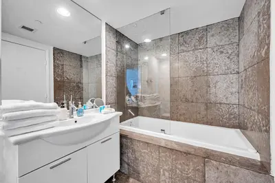 a white bathroom with a tub and a sink and a bath tubermott at Unique 1BR Icon Brickell WaterViews-Freespa in Miami