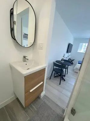 a bathroom with a sink and a mirror and a table at Excellent location Miami Brickell Studio in Miami