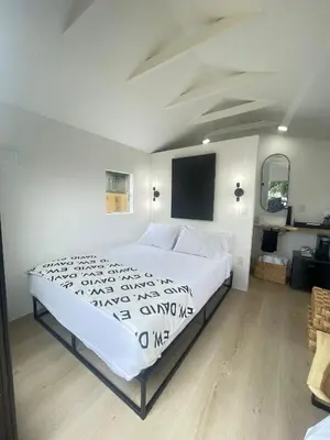 a bedroom with a white bed and a flat screen tv at Charming Coastal Retreat in Miami