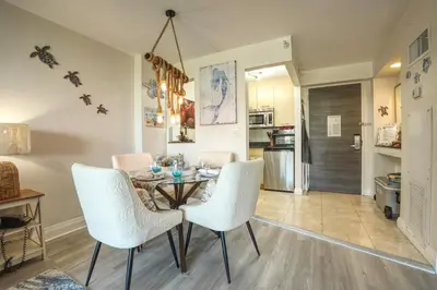 a dining room with a table and white chairs at GalleryOne Doubletree Hilton GC Turtle Cove in Fort Lauderdale
