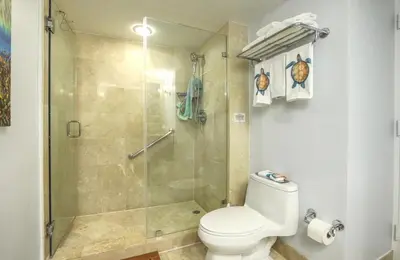 a bathroom with a toilet and a glass shower at GalleryOne Doubletree Hilton GC Turtle Cove in Fort Lauderdale