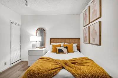 a bedroom with a bed with a yellow blanket on it at Tropical Retreat with Beach Resort Amenities in Miami