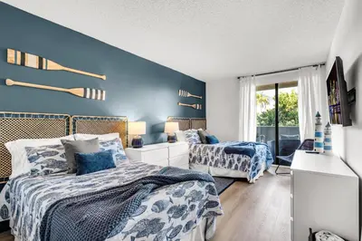 two beds in a bedroom with blue walls at Tropical Retreat with Beach Resort Amenities in Miami