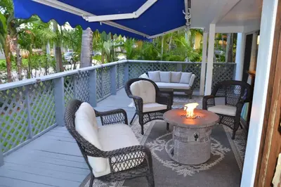 a porch with chairs and a table with a candle on it at Beautiful Tropical Vacation House close to Beach in Hollywood
