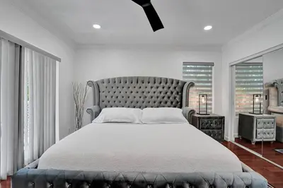 a bedroom with a large bed with a large headboard at Beautiful Tropical Vacation House close to Beach in Hollywood