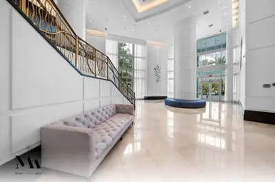 a living room with a couch and a staircase at FontaineBleau, Balcony w Ocean plus Bay and City View in Miami Beach