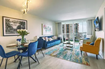 a living room with a blue couch and a table at GalleryOne Doubletree Hilton GC Secret Blending in Fort Lauderdale