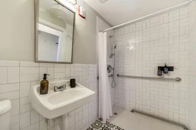 a white bathroom with a sink and a mirror at Tower Hotel Little Havana in Miami