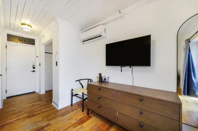 a living room with a tv and a dresser at Tower Hotel Little Havana in Miami