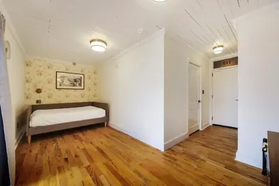 a bedroom with a bed and a wooden floor at Tower Hotel Little Havana in Miami