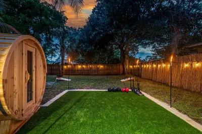 a backyard with a play yard with a wooden fence at Zen Retreat - Sauna Pool Cold Plunge & More in Fort Lauderdale
