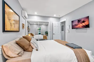 a bedroom with a bed and a tv on the wall at Zen Retreat - Sauna Pool Cold Plunge & More in Fort Lauderdale