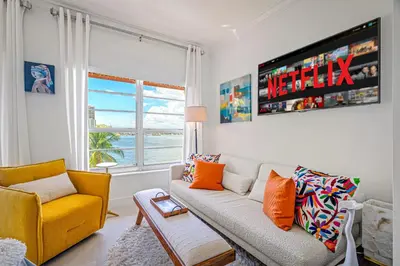 a living room with a couch and a yellow chair at Walk to Ft Lauderdale beach - Water Views & Pool in Fort Lauderdale