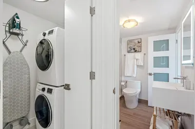 a bathroom with a washer and dryer next to a sink at Walk to Ft Lauderdale beach - Water Views & Pool in Fort Lauderdale