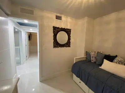 a bedroom with a bed and a mirror on the wall at Luxury Beachfront 3 Bedroom Miami Beach Condo, in Miami Beach