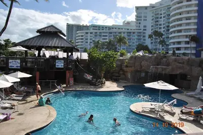 a group of people in a pool at a resort at Luxury Beachfront 3 Bedroom Miami Beach Condo, in Miami Beach