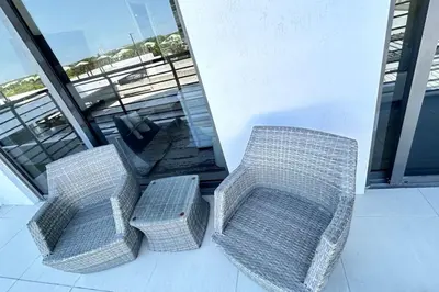 two wicker chairs and a table on a balcony at Resort Style Luxury Living in Doral, Miami in Miami