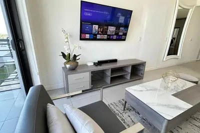 a living room with a couch and a tv on a wall at Resort Style Luxury Living in Doral, Miami in Miami