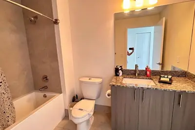 a bathroom with a toilet and a sink and a mirror at Resort Style Luxury Living in Doral, Miami in Miami