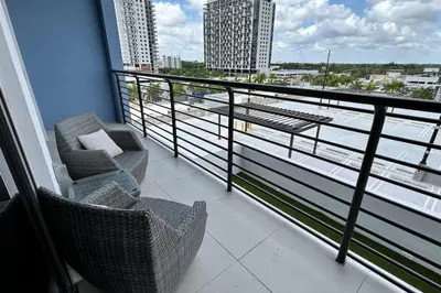 a balcony with two chairs and a view of the water at Resort Style Luxury Living in Doral, Miami in Miami