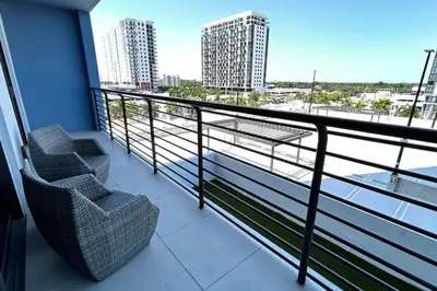 a balcony with two chairs and a view of the water at Resort Style Luxury Living in Doral, Miami in Miami