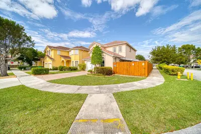 a house with a fence in the grass at Casa grande con piscina-Palmetto Eliptic Miami- in Tamiami