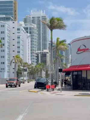 a city street with palm trees and tall buildings at New Mid Miami Beach apt free parking and beach access in Miami Beach