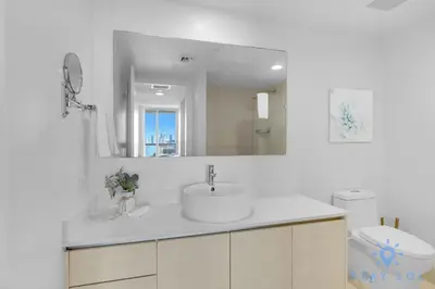 a bathroom with a sink and a mirror and a toilet at Infinite View Amazing Apt Spectacular Amenities in Hallandale Beach