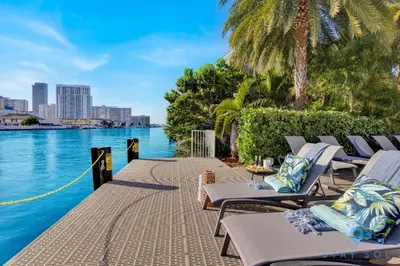 a row of lounge chairs next to a body of water at Spacious studio Amazing Amenities Infinite View in Hallandale Beach