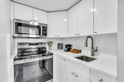 a white kitchen with a stove and a sink at Gorgeous coastal PH with Large Private Terrace in Miami Beach