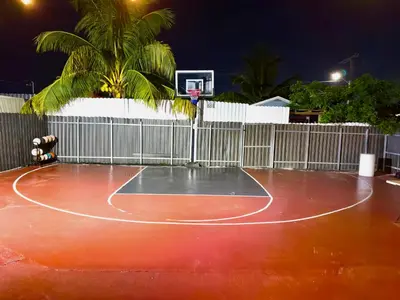 a basketball court at night with a basketball hoop at Luxury home 5 minutes from stadium in Miami