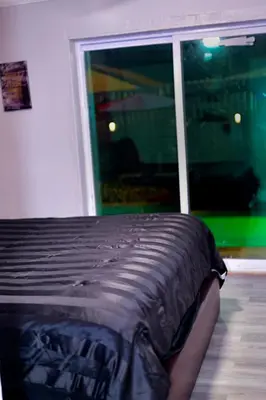 a bed in a room with a large window at Luxury home 5 minutes from stadium in Miami