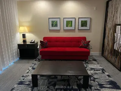 a red couch in a living room with a table at Doral Pool 404 by Wave Properties in Miami