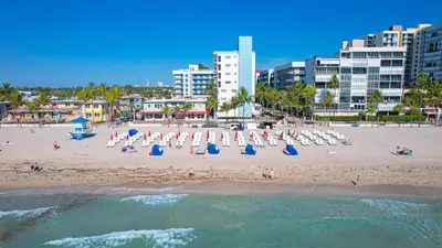 a beach with chairs and umbrellas and people on it at Nido del amor in Hollywood
