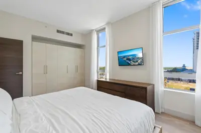 a white bedroom with a bed and a tv at Nido del amor in Hollywood