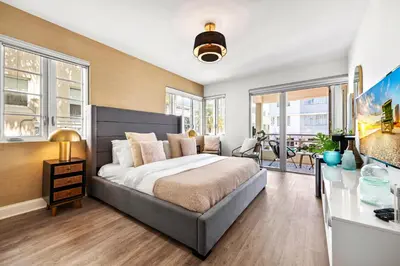 a bedroom with a large bed and windows at Luxuri Suites in Miami Beach