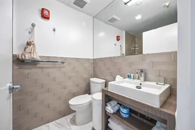 a bathroom with a white sink and a toilet at Luxuri Suites in Miami Beach