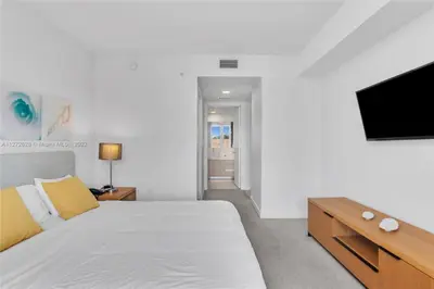 a bedroom with a bed and a flat screen tv at Spectacular 1BR Resort Pool Gym Near Beach in Hallandale Beach