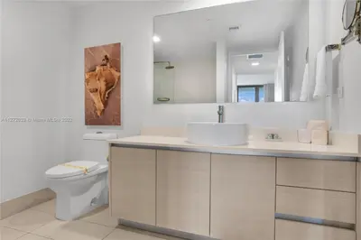 a bathroom with a sink and a toilet and a mirror at Spectacular 1BR Resort Pool Gym Near Beach in Hallandale Beach