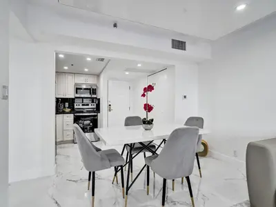 a white dining room with a white table and chairs at High Floor Miami Beach Pool Beach Service 1219 in Miami Beach