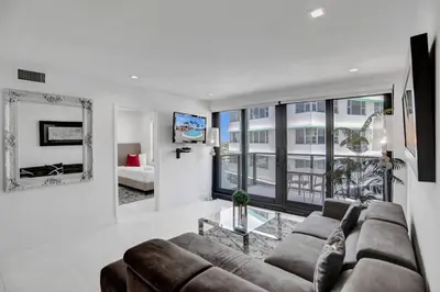 a living room with a couch and a table and a tv at High floor 2BD with beach service 1616 in Miami Beach