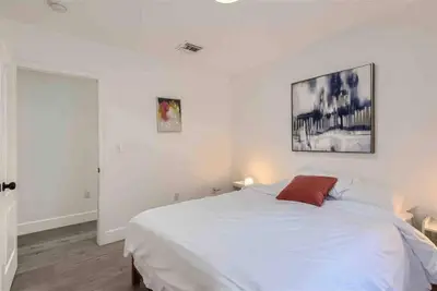 a bedroom with a white bed and a painting on the wall at Modern Miami House 2Baths Design District in Mins in Miami